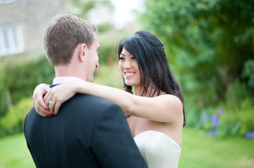 Professional colour photograph of a bride and groom holding each other in a garden